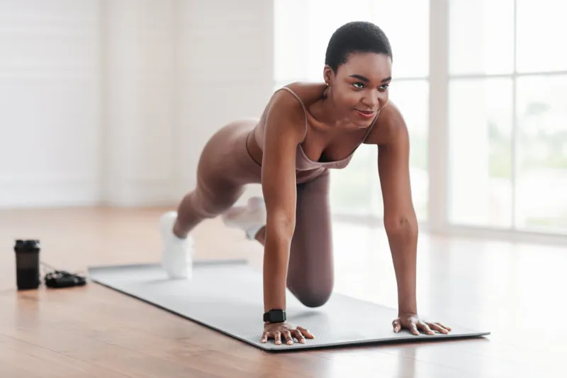 workout routine fit active athletic black woman doing mountain climbers exercise on yoga mat, strong sporty female in sportswear training abs core muscles in gym, fitness studio or at home