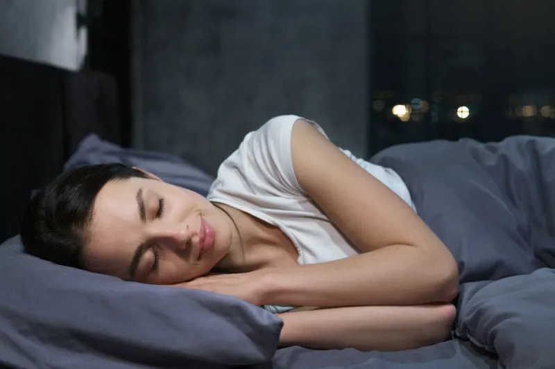 young female sleeping peacefully in her bedroom at night, relaxing