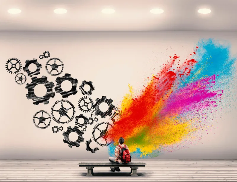 young man sitting in a room divided by brain hemispherescreative half and logical half