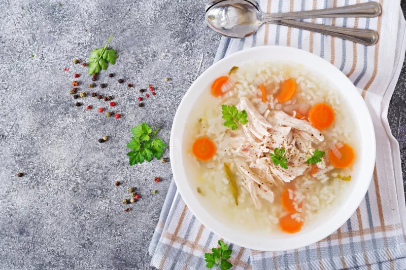 dietary chicken soup with rice and carrots healthy food flat lay top view