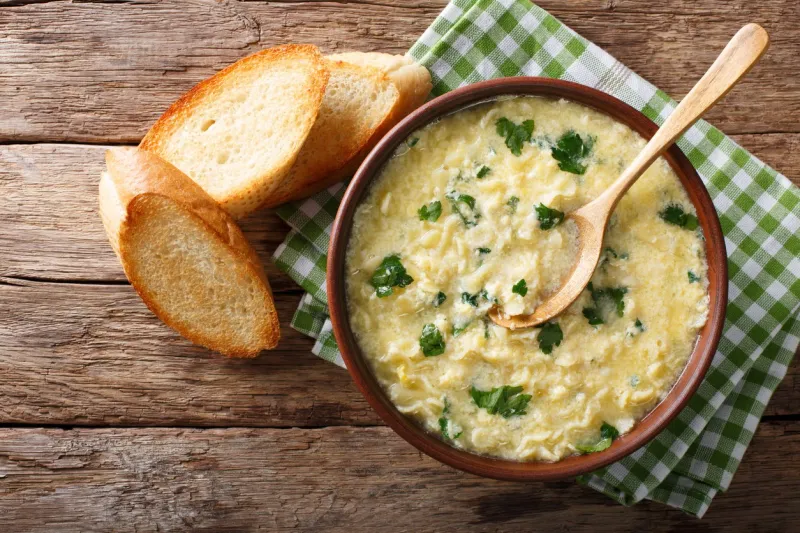 italian egg soup stracciatella with farfalline pasta and parmesan close-up in a bowl horizontal view from above