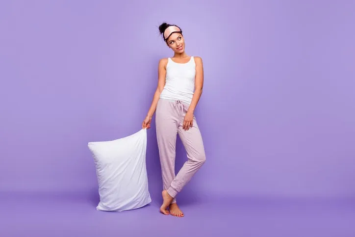 full length body size photo beautiful she her lady look empty space wondered thoughtful hold hand arm pillow barefoot wear sleeping mask pants tank-top pajamas isolated violet purple background