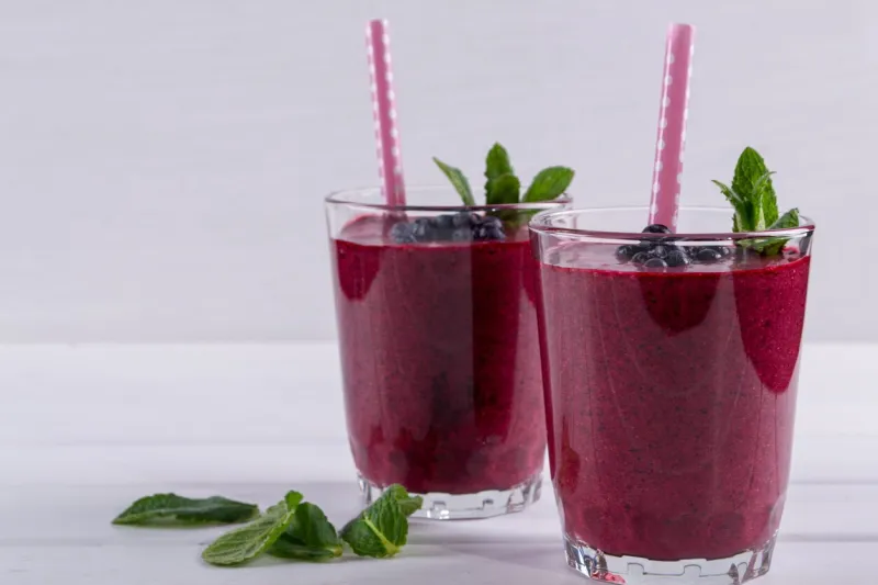 homemade organic blueberry smoothy with berries and mint leaf