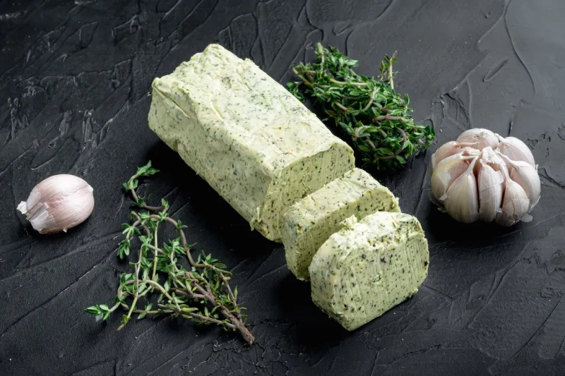 fresh green herb butter set, on black stone background