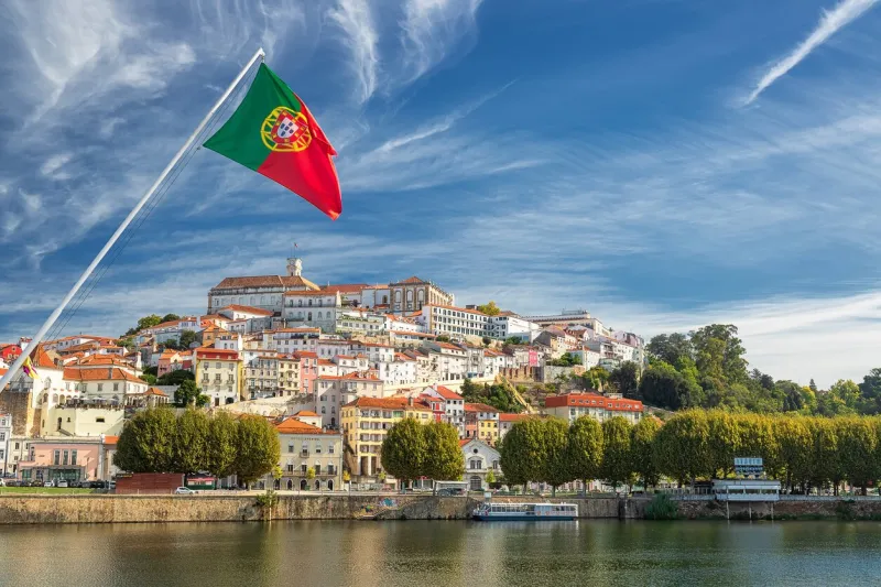 view on the old university city of coimbra and the medieval capital of portugal with portuguese flag, europe