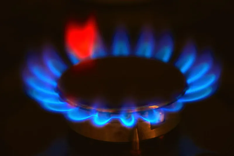 brûlant cuisinière à gaz cuisinière bleu flammes se bouchent dans l'obscurité sur un fond noir
