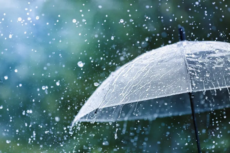 transparent umbrella under heavy rain against water drops splash background rainy weather concept