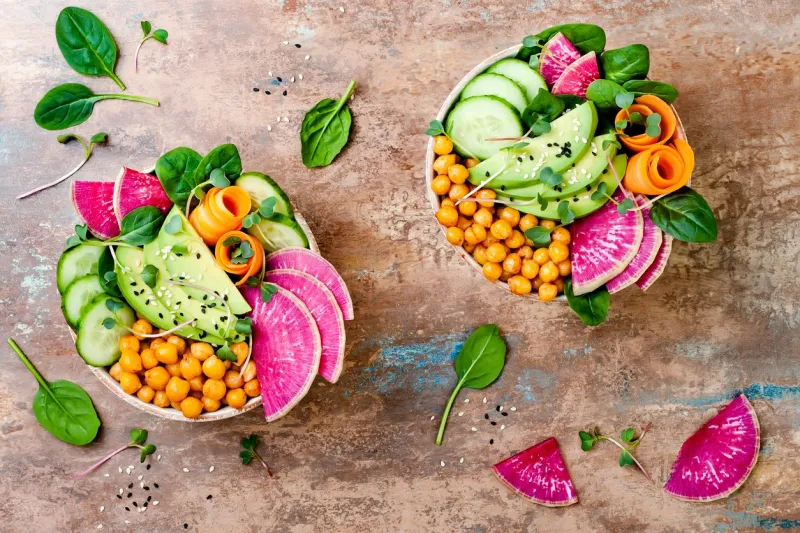 vegan, detox buddha bowl recipe with avocado, carrots, spinach, chickpeas and radishes top view, flat lay, copy space