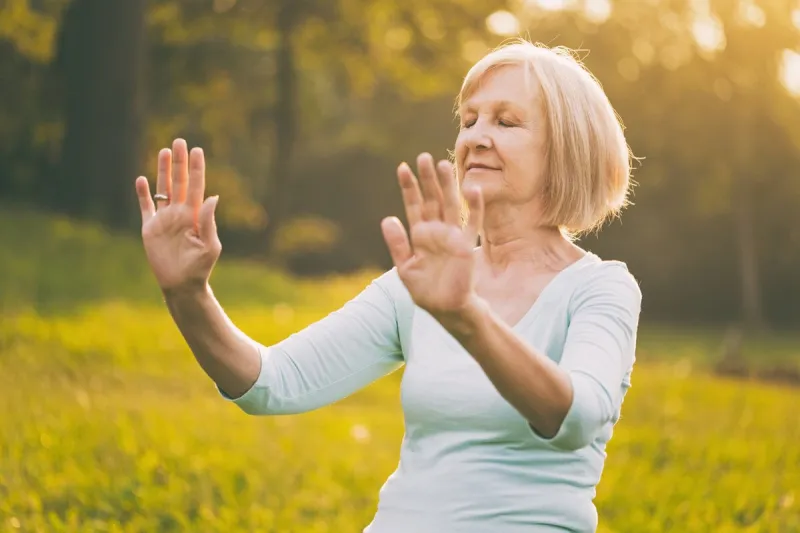 senior woman enjoys exercise tai chi in the natureimage is intentionally toned
