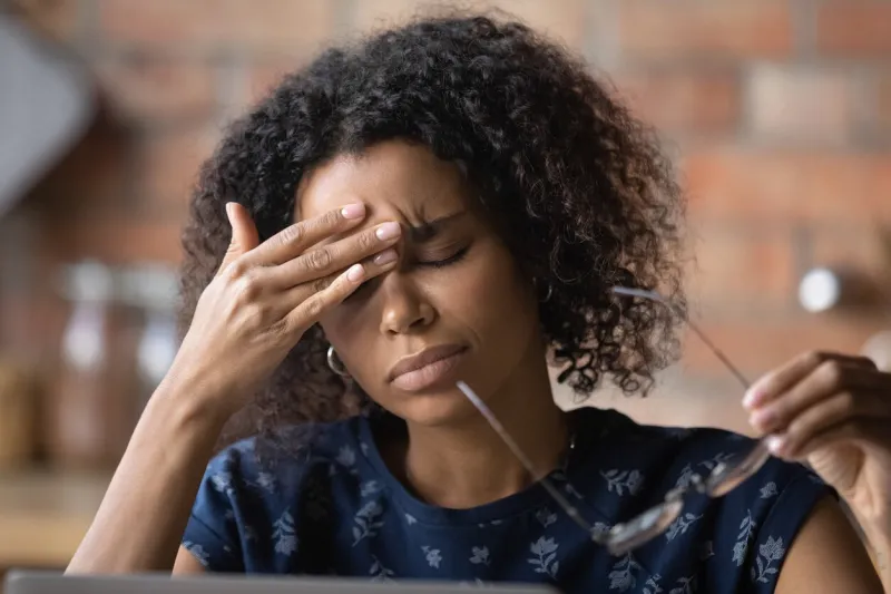 frustrated black female freelancer overworked by computer feel headache migraine take off eyewear rub nose bridge exhausted tired young biracial lady suffer of eye pain vision problem chronic fatigue