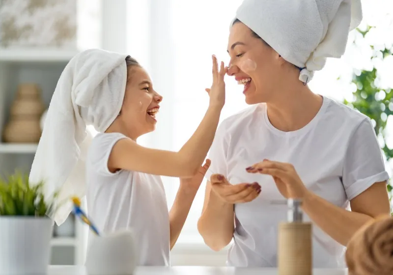 happy family mother and daughter child girl are caring for skin in the bathroom