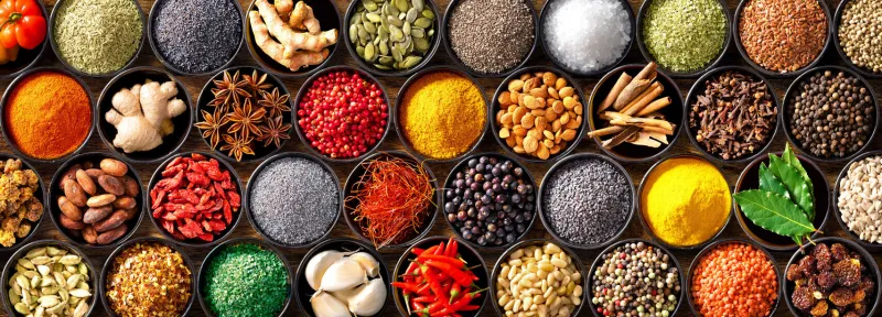 colourful background from various herbs and spices for cooking in bowls top view
