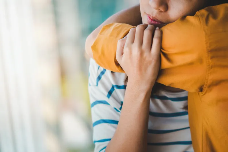 young depressed asian woman hug her friend for encouragement, selective focus, ptsd mental health concept