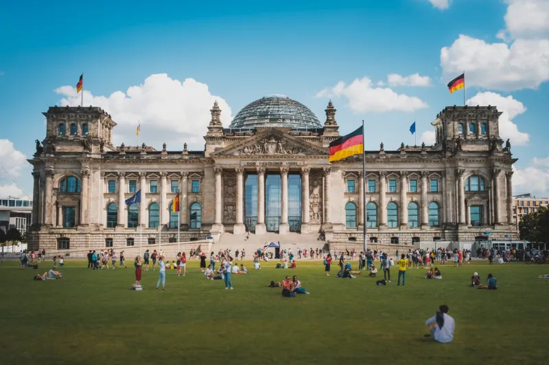 berlin, germany - august, 2019  many people on meadow in front of the reichstag building (german bundestag), a famous landmark on a sunny, summer day in berlin, germany