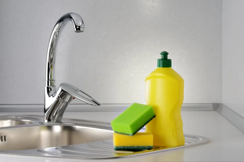 dishwashing liquid with a sponge on kitchen sink