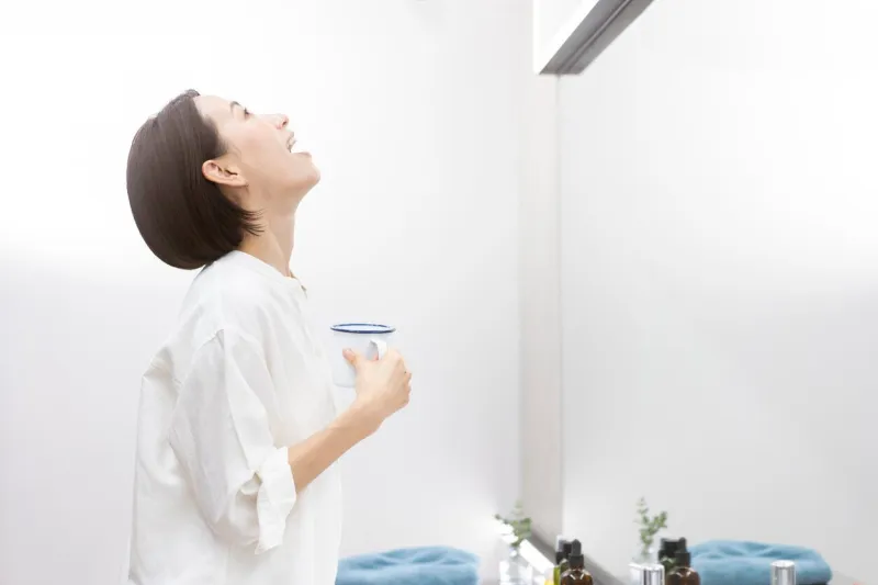 a middle-aged japanese woman is gargling