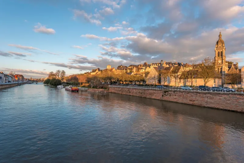 view of sarthe river and le mans historic area in evening lights, pays de la loire, france
