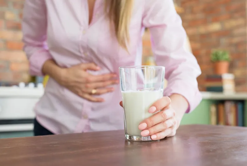 woman having pain in stomach, feeling sick by drinking milk