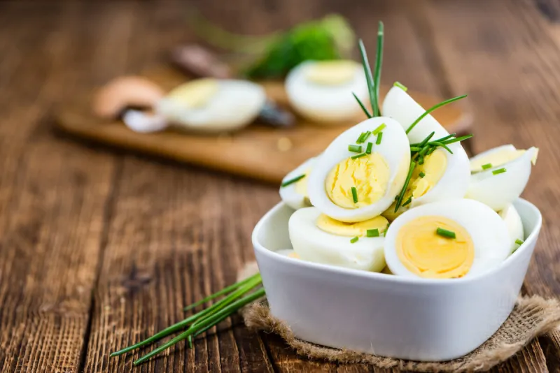 halved eggs on wooden background (close-up shot, selective focus)
