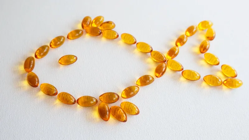 fish shape oil capsules health care and medical concept