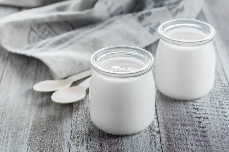 greek yogurt in a glass jars with wooden spoons on wooden background healhty breakfast food copy space