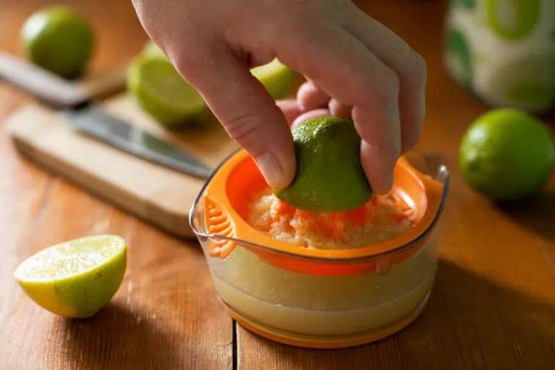 caucasian hand squeeze lime on manual juicer
