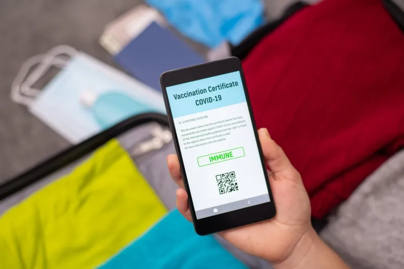 unrecognizable woman holding mobile phone with digital vaccination certificate as proof for getting vaccinated according to all the international guidelines