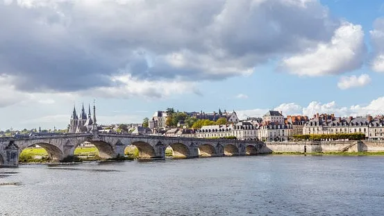 cityscape blois in france with ancient stone bridge jacques-gabriel over the loire river and eglise saint-nicolas in the background
