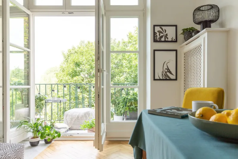 tenement house with a balcony decorated with plants close-up of fruit on a table