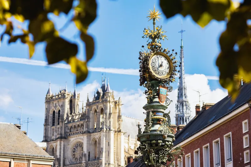 historic street clock with the famous amiens cathedral in the background, amiens, hauts-de-france, france