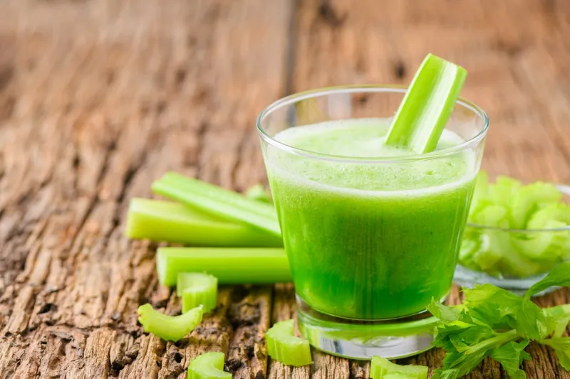 fresh green celery juice in glass on wooden brown background, healthy food, detox and healthy concept