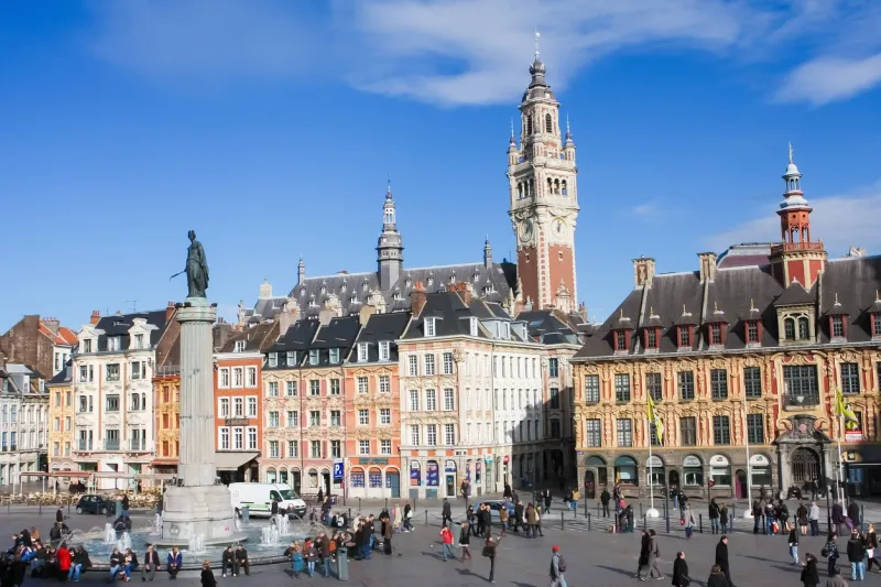 lille, france - november 2, 2009  unidentified people near the chambre of commerce and statue and column of deesse (1845) at the place general de gaulle in lille, france