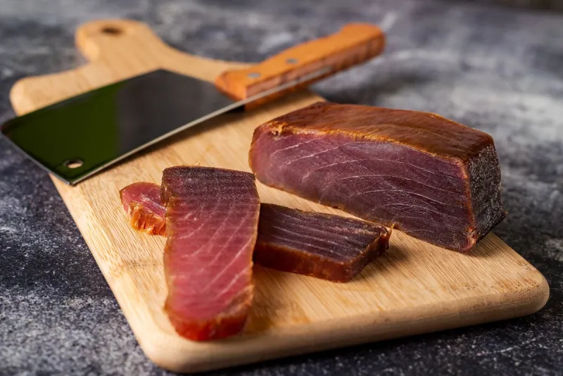 piece of tuna mojama or cecina cut into slices on a cutting board, close-up