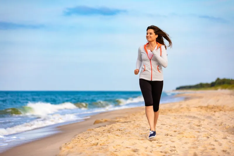beautiful woman running on sunny beach