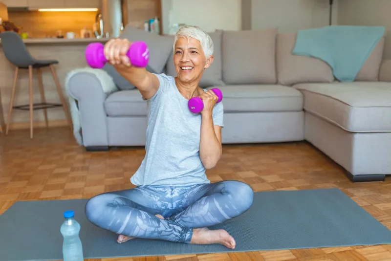 woman exercising with dumbbell at home feeling great inside and out age is no excuse to slack on your health portrait of smiling senior woman holding dumbbell