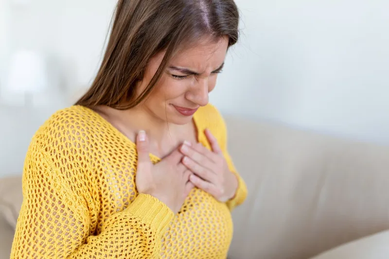 young woman having chestpain,acute pain, possible heart attackeffect of stress and unhealthy lifestyle concept