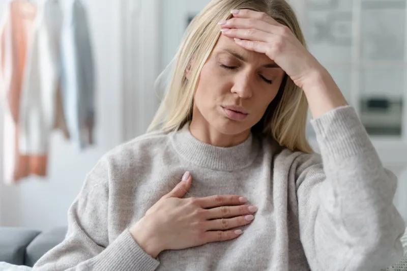 blonde young female in sweater feel fatigue, asthma attack or dyspnea at home illness girl with headache and cardiac pain