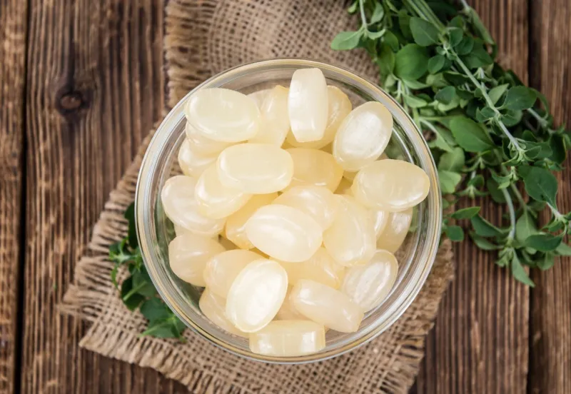 portion of menthol candies (close-up shot, selective focus) on wooden background