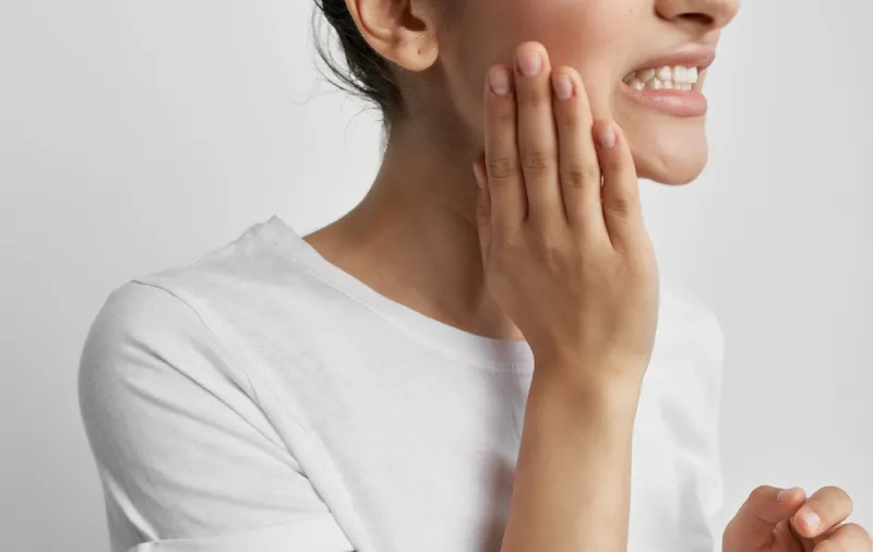 young woman applying moisturizer cream on her face