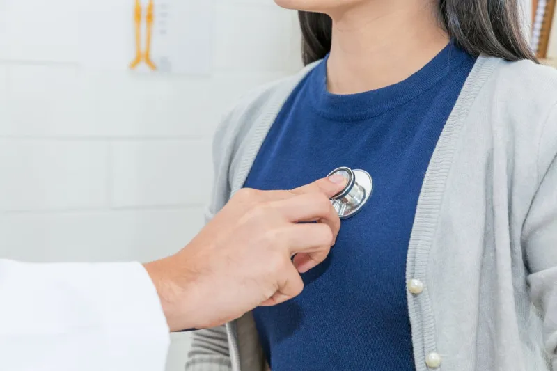 close up of doctor using stethoscope to exam heart and lungs of