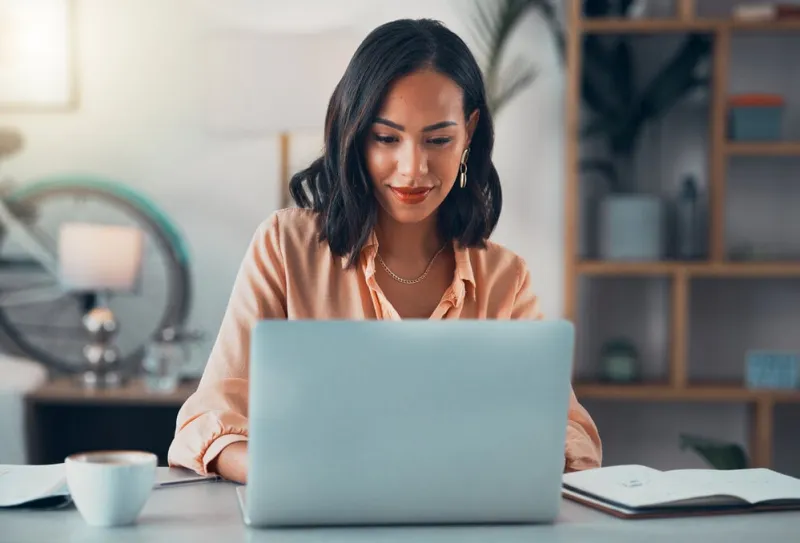 woman working on laptop online, checking emails and planning on the internet while sitting in an office alone at work business woman, corporate professional or manager searching the internet