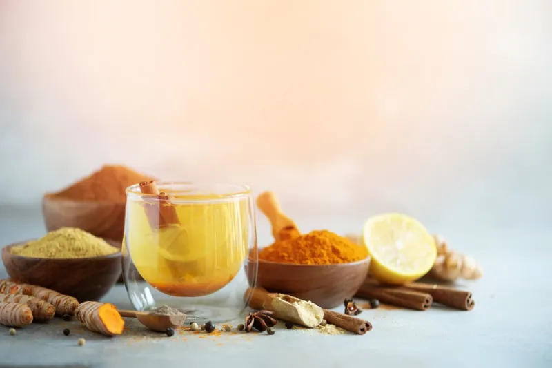 ingredients for turmeric hot tea on grey background healthy ayurvedic drink with lemon, ginger, cinnamon, turmeric immune boosting remedy