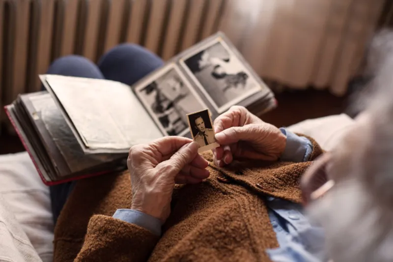 senior adult woman looking at an old photo of her husband