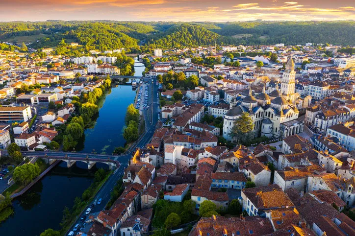 drone view of french city of perigueux on isle river overlooking romanesque building of ancient cathedral during summer sunset