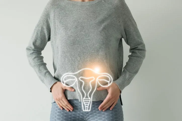 woman in casual grey clothes suffering from indigestion pain, highlighted vector visualisation of uterus