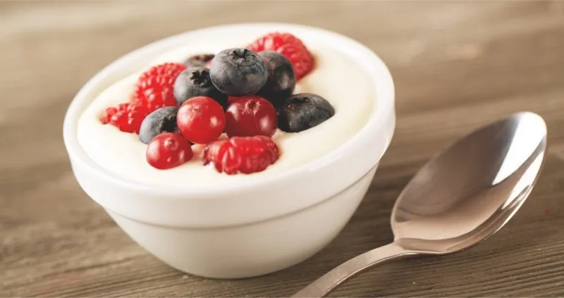 yogurt with forest berries on wooden table