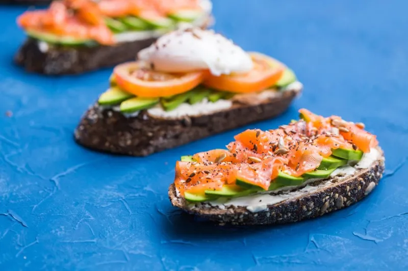 sandwiches with smoked salmon and avocado on blue background concept for healthy nutrition