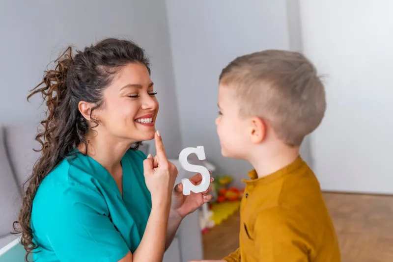 cute little boy at speech therapist office shot of a speech therapist during a session with a little boy boy and young woman teacher during private home lesson