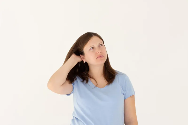 young beautiful girl with long ginger hair wearing blue t-shirt freelancer looking away with confused disappointed expression, scratching head student not remembers information for exam