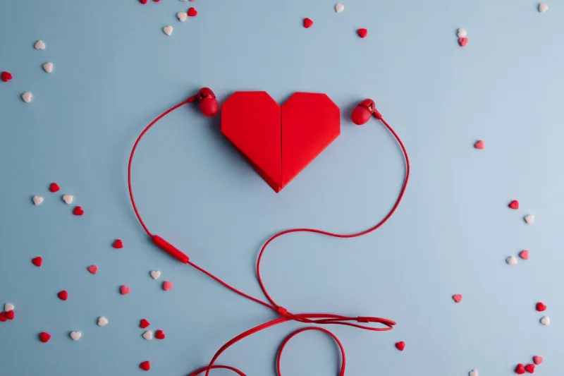 listen to your heart red origami heart with headphones on blue background love listening to music